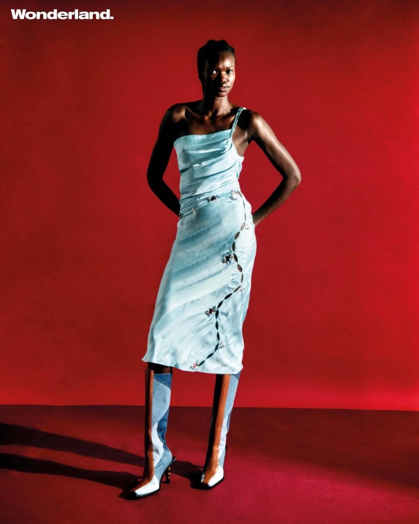 Wonderland editorial: medium shot on red set in one-shoulder pink and green illusion-knit mini dress